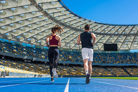男女运动员在体育场赛马场上跑步图片
