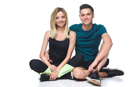穿着运动服的运动型年轻夫妇坐在被白色图片