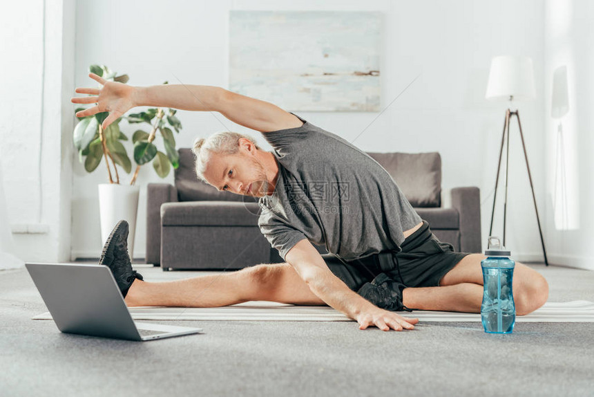 运动成人男子在瑜伽垫上伸展图片