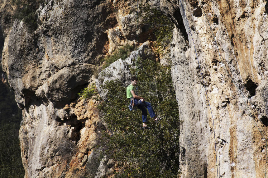 男子攀岩者攀岩者爬上石墙男人做图片