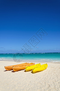 热带沙滩上的黄和橙黄色皮艇在大片海洋图片