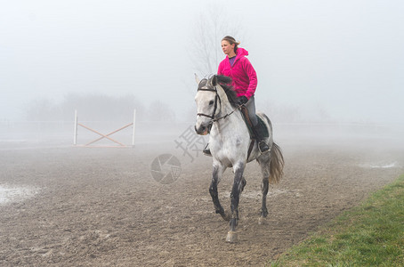 雾中骑行的年轻女子图片