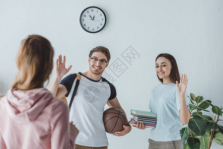 有书和篮球向朋友挥手的图片