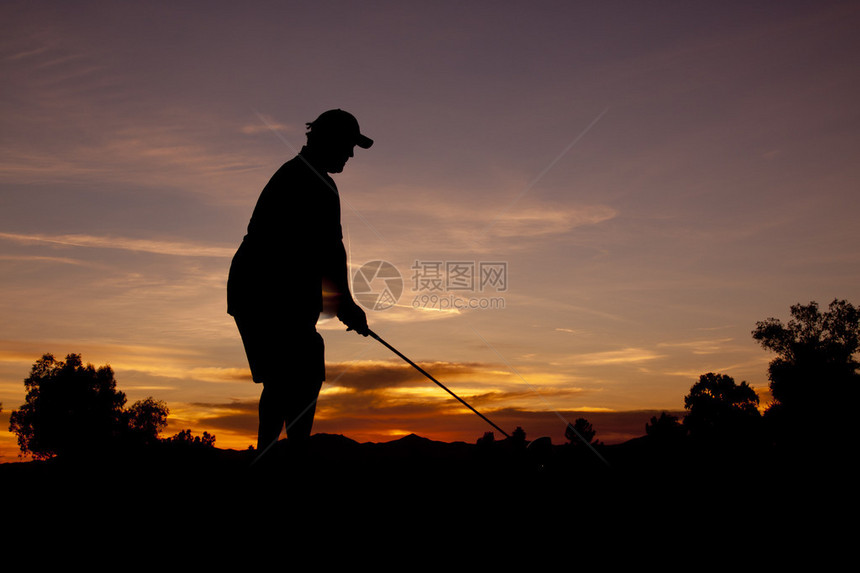 一个高尔夫球手在美丽的夕阳下图片