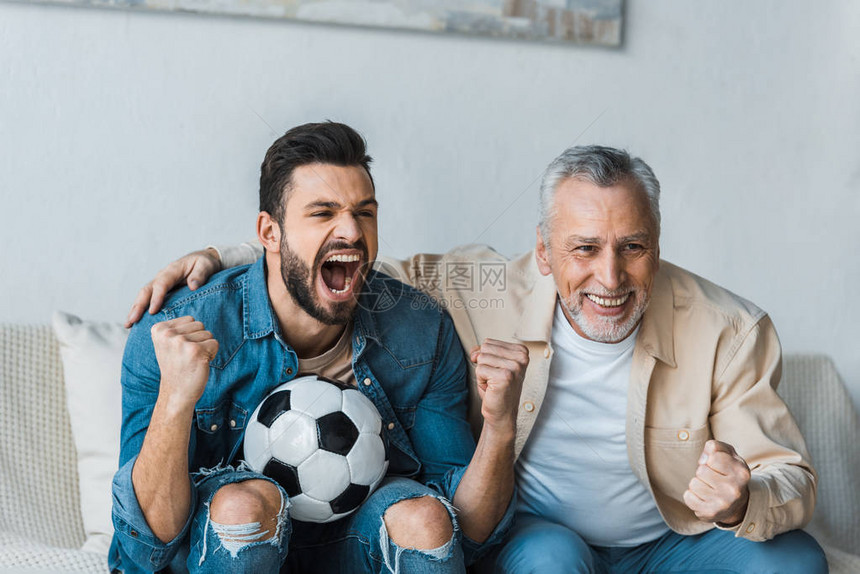 快乐的老年人在看冠军赛和英俊的儿子图片