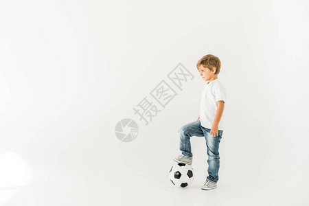 小男孩玩足球的一面孤立在白背景图片