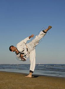 一个年轻人在沙滩上练跆拳道图片