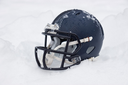 被冰雪覆盖的美式橄榄球头盔背景图片
