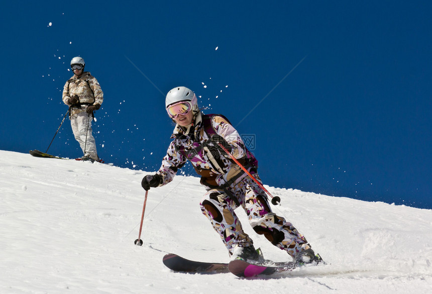 女子滑雪者在太阳下深雪中跌图片