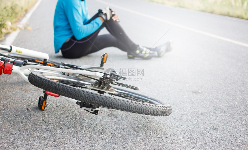 骑自行车的人从自行车上摔下来膝盖关节受图片