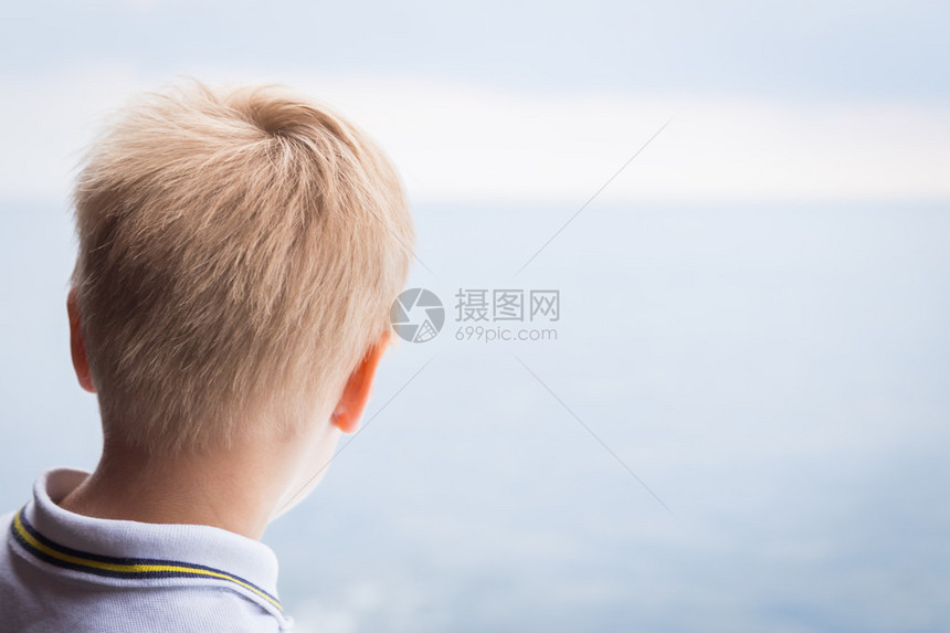 男孩从船的甲板上望着大海图片