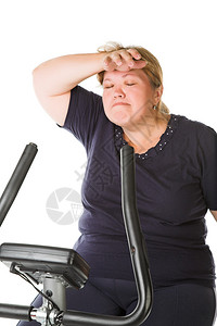 在自行车上训练疲惫的胖女人图片