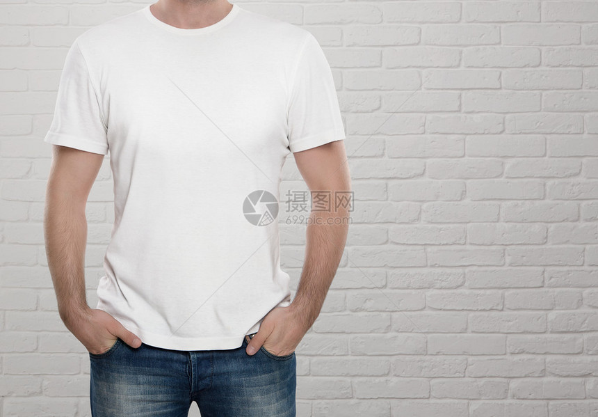 男子在白砖墙上穿着空白的T恤衫图片