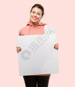身穿运动衫的年轻运动女手持空白广告横幅广告报价或公告的好海报图片