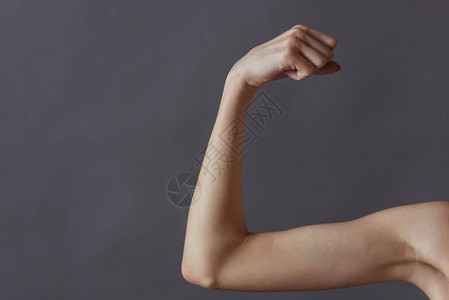 以灰色背景展示手臂肌肉的女孩图片