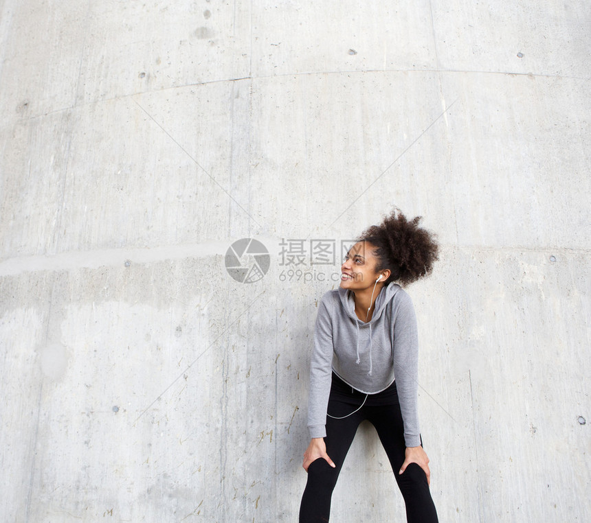 一位快乐的年轻黑人运动女运动员用耳图片