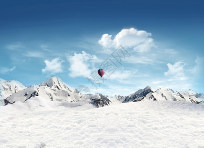 热气球飞蓝天的雪地和山景图片