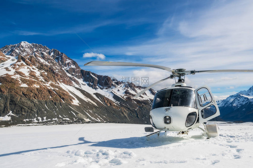 直升机降落在新西兰库克山塔斯曼冰川的雪山上库克山的直升机服务提供观光飞行冰川降图片