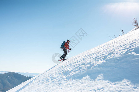 穿雪鞋的登山者背着包冬天在山上旅图片