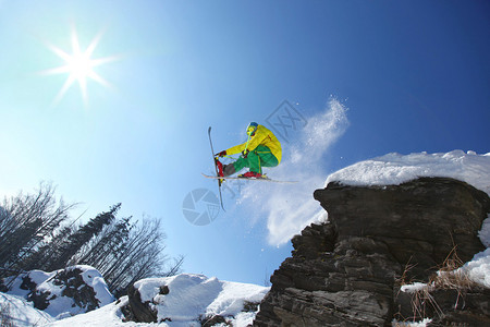 滑雪者从高山的悬崖上跳下空中图片