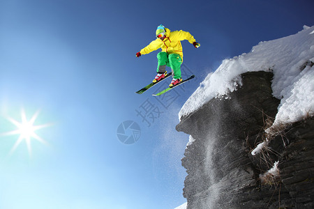 滑雪者从高山的悬崖上跳下空中图片