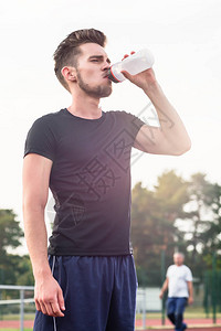训练期间从水瓶中喝水的人图片