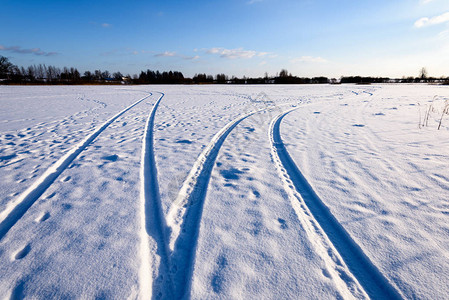 深雪中覆盖的冬季雪路车胎轨迹向高清图片