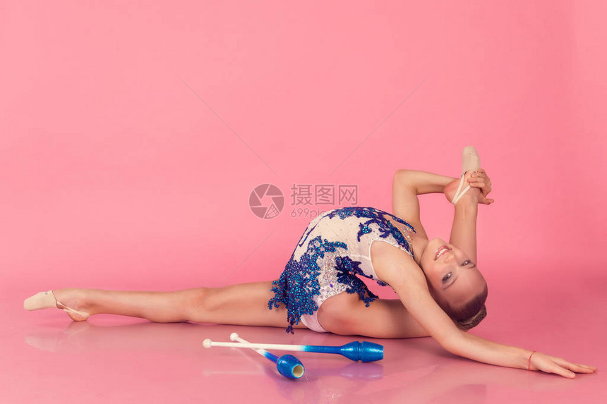 穿蓝裙子的少女在有粉红色背景的地板图片