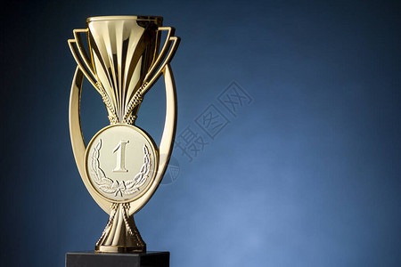 金锦标冠军奖杯或子放在蓝色背景和复背景图片