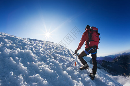 独自登山者到达高山峰顶端图片