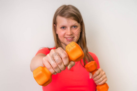 在健身房用哑铃锻炼的健身女人图片
