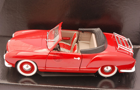 一个肮脏的红色出租车汽玩具给身着光亮背景图片