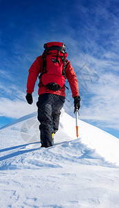 登山者在雪峰顶上行走图片