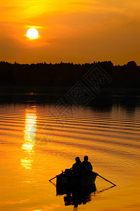 日落时船上的渔民图片