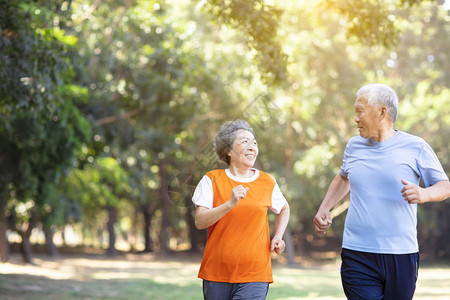 快乐的老年夫妇在公园里跑步图片