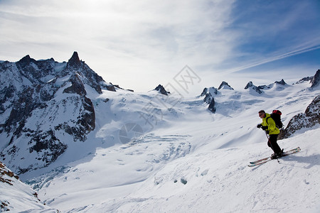 男滑雪运动员以雪粉向下移动图片