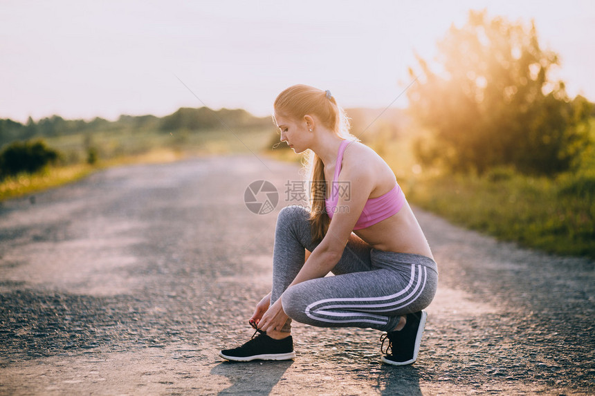 女在锻炼前穿鞋健身和健康的生活方式概图片