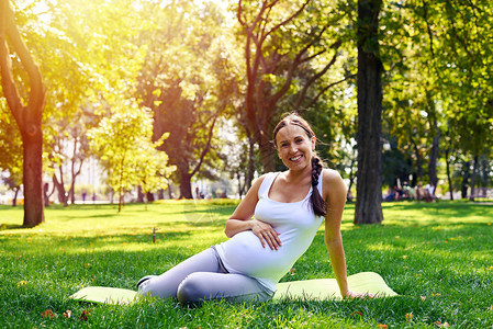 公园瑜伽锻炼时快乐孕妇手放在图片