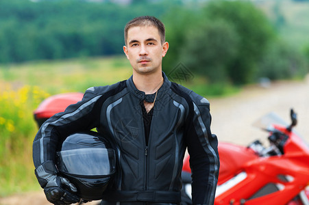 穿着手头戴盔的摩托车与摩托车背景夏日图片