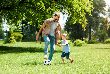 爸和儿子在公园踢足球图片