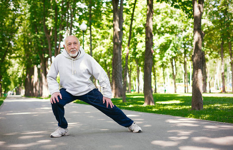 运动型老人在阳光明媚的夏日公园晨练时锻炼身体图片