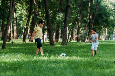在绿草地上踢足球的可爱背景图片