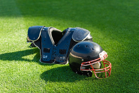 美国足球头盔胸罩保护在绿草上的图片