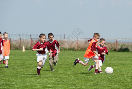 在体育场踢足球的儿童参加足球图片