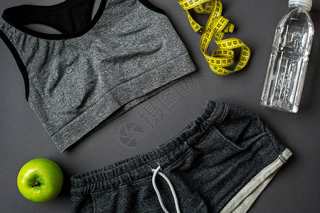 在灰色背景顶视图上提供健身食品和运动器材的锻炼计划复图片