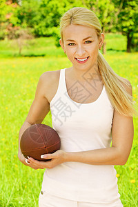 身着橄榄球的白种运动女郎的美丽年轻少女肖像图片