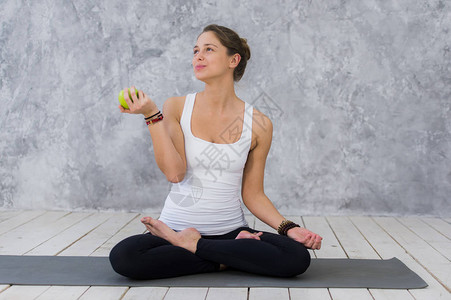 高加索美丽的健康运动女运动员在训练后吃绿苹果图片