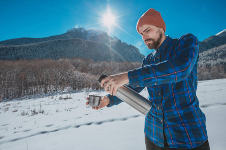 在雪山上拿着保温瓶的男人图片