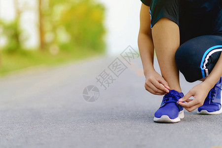 尝试跑鞋的女童选手准备参加慢跑健康妇女培图片