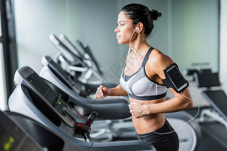 运动型黑发女子在健身体育场跑步机上运动的肖像图片